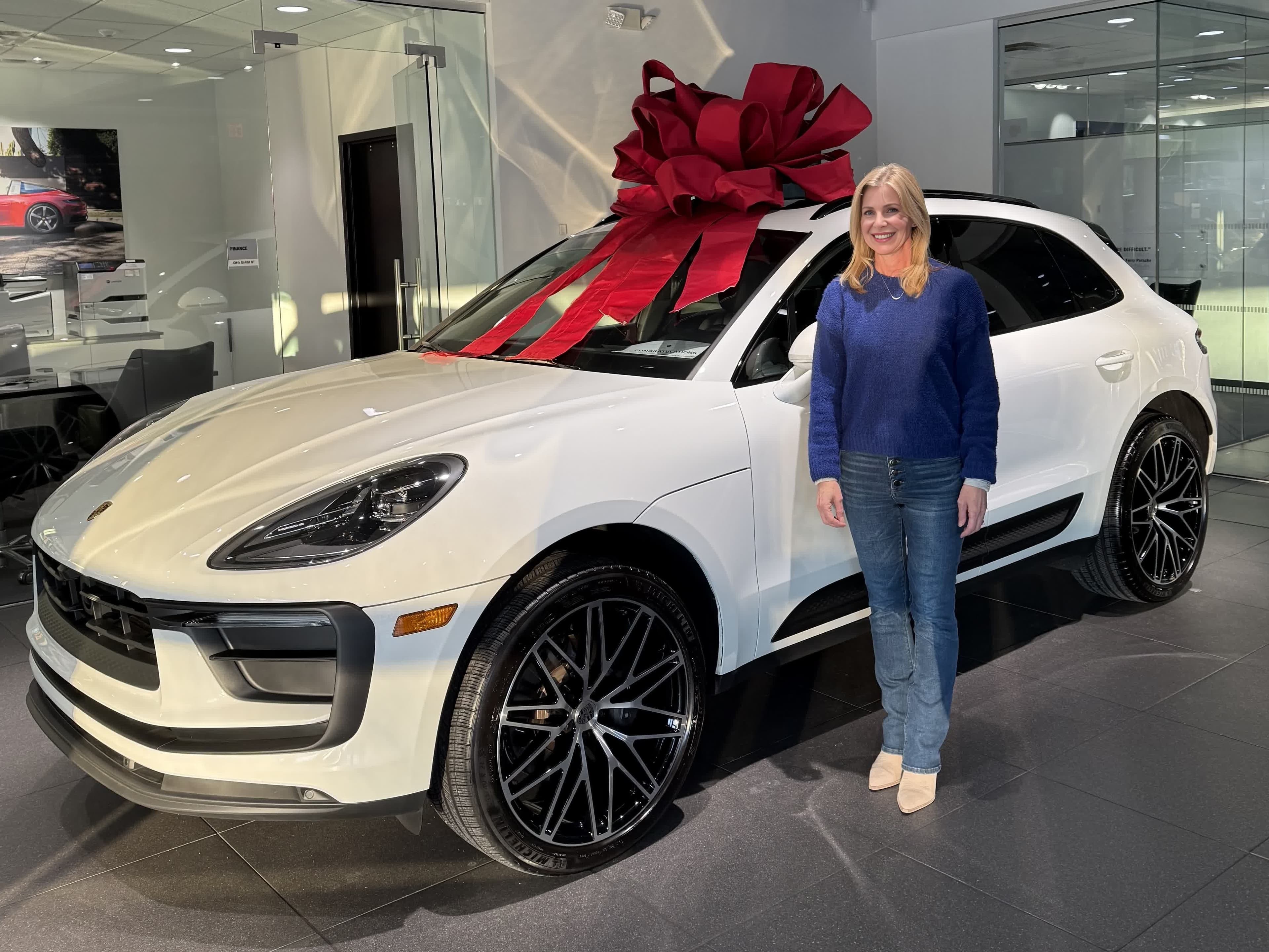 Happy customer with a new white Porsche Macan at the dealership